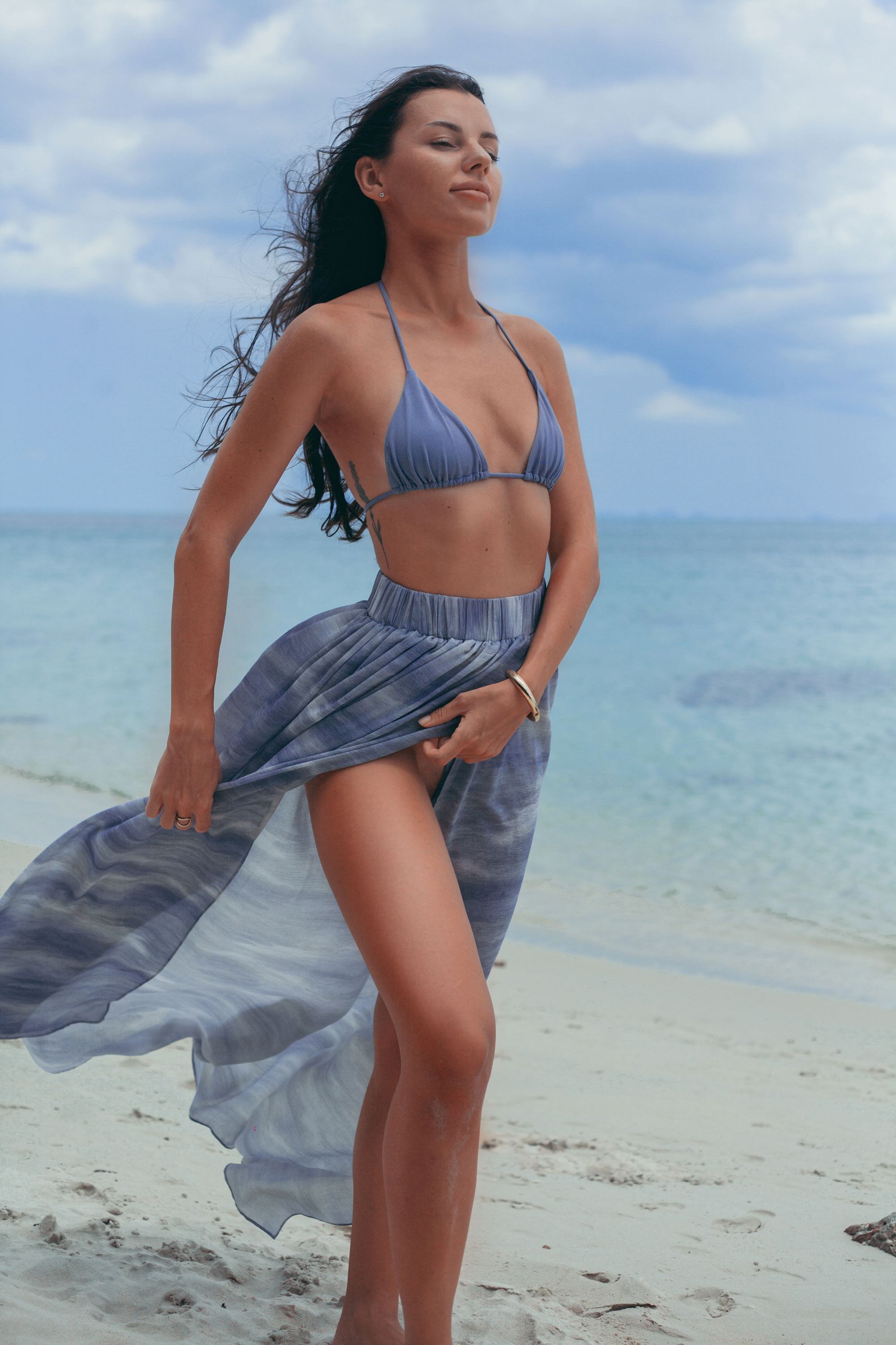 Elara Wrap Maxi Skirt with graceful movement in soft blue tones, elegant luxury resort skirt