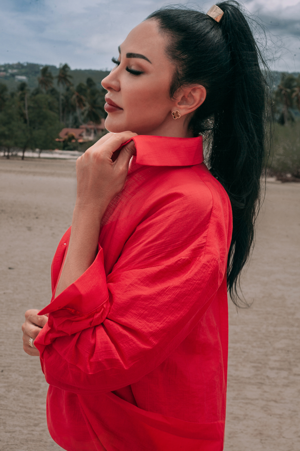 Close-up side view of Carmine Relaxed Shirt by INNEVIA, showing the fluid deep red fabric, relaxed fit and long sleeves