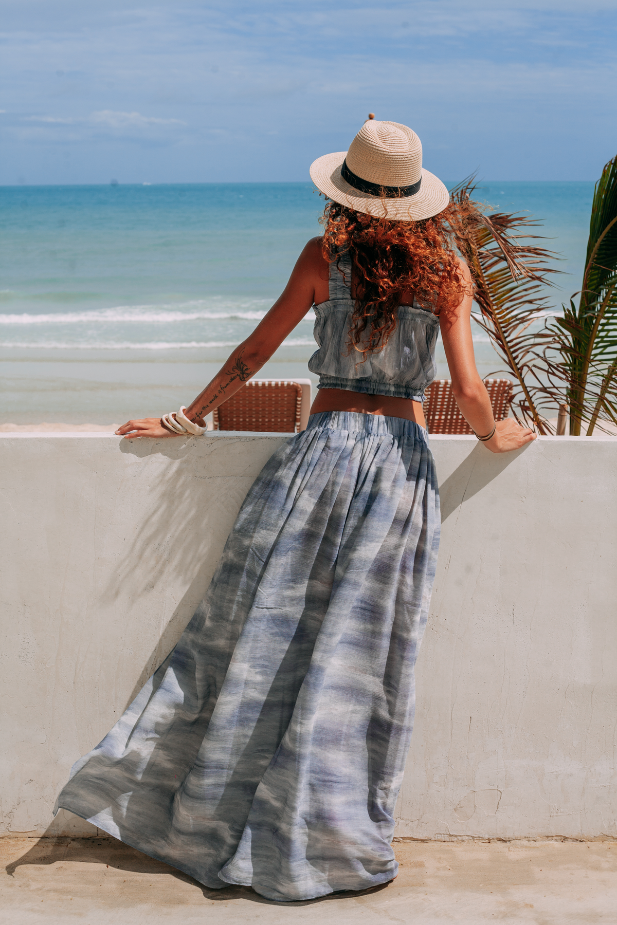 Elara two-piece resort set from the back, styled with a sun hat by the sea