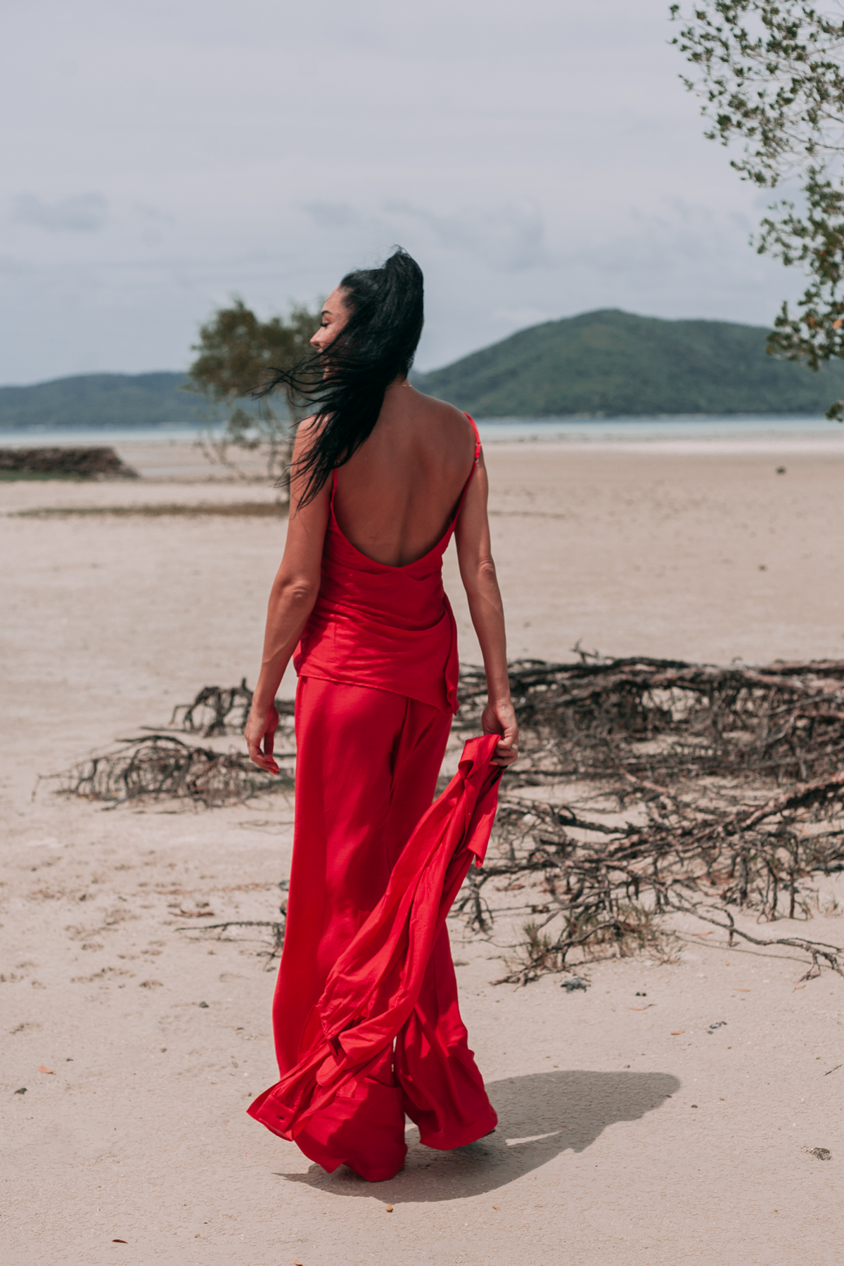 Back view of Carmine red open-back top with adjustable straps and wide-leg trousers by INNEVIA
