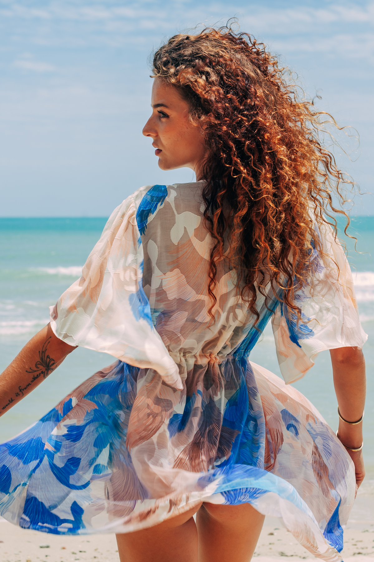 Aveline Mini Tunic in blue and white print, back view with flowing hem