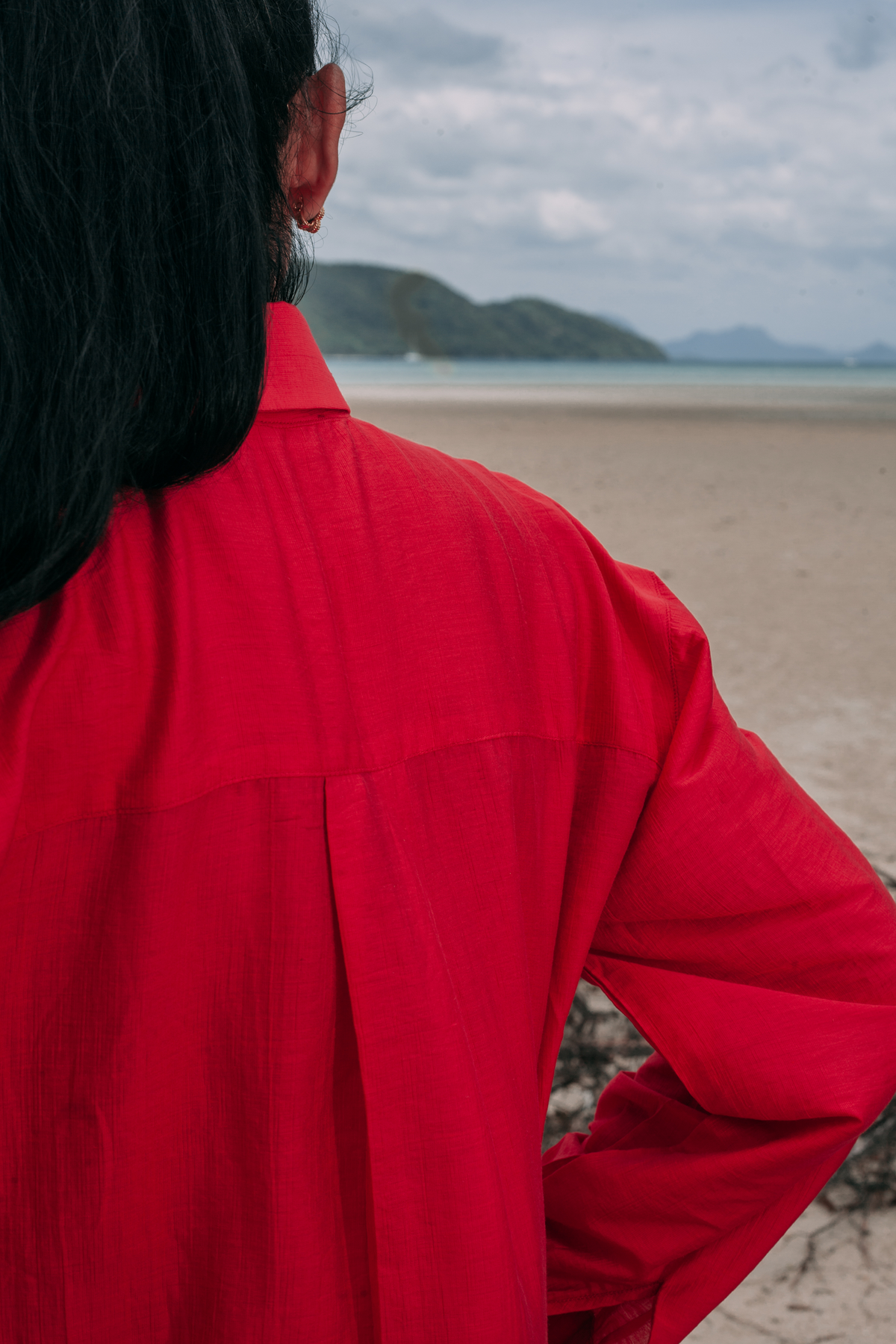 Back detail of Carmine Relaxed Shirt by INNEVIA, showing the relaxed drape and fluid rayon-silk blend against a beach backdrop