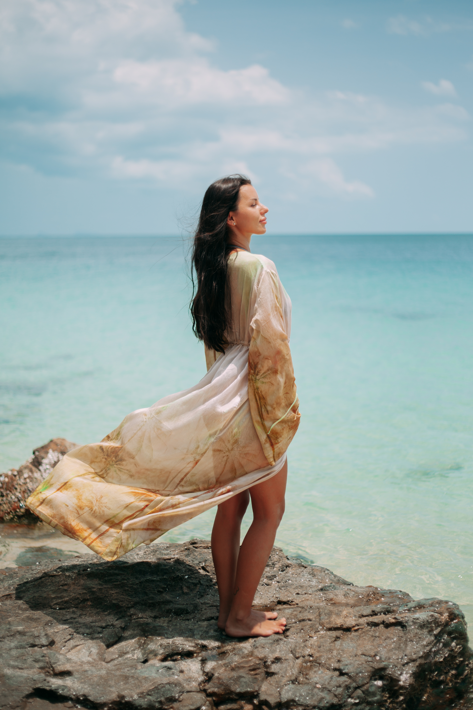 Selara Maxi Tunic flowing in the ocean breeze on a tropical shoreline